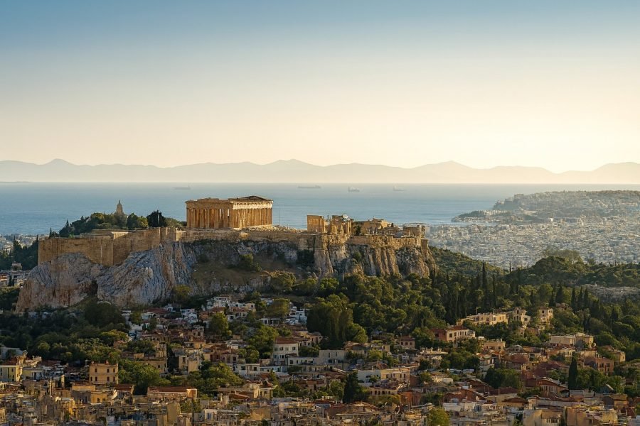 Acropolis of Athens with the Parthenon overlooking the city and the Aegean Sea at golden hour.