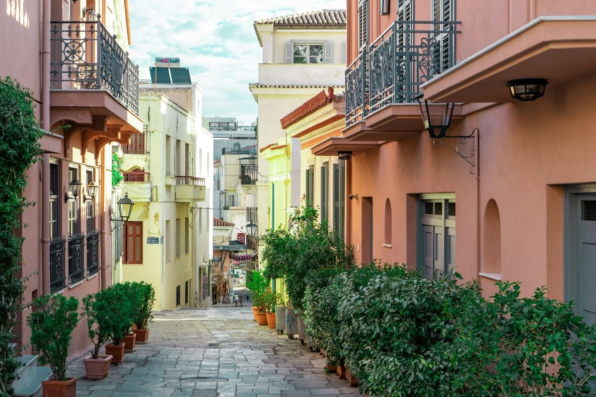 Quiet neoclassical street in Athens with pastel buildings and greenery, reflecting a calm, local walking experience