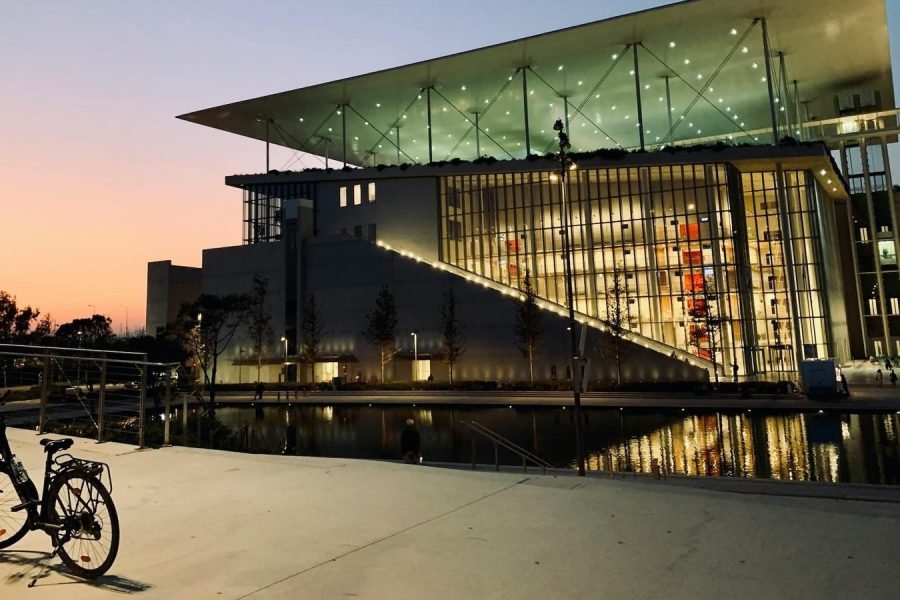 Stavros Niarchos Cultural Center in Athens at sunset with canal reflections
