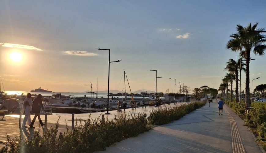 Palm-lined waterfront promenade in Glyfada, Athens Riviera, with marina views at sunset