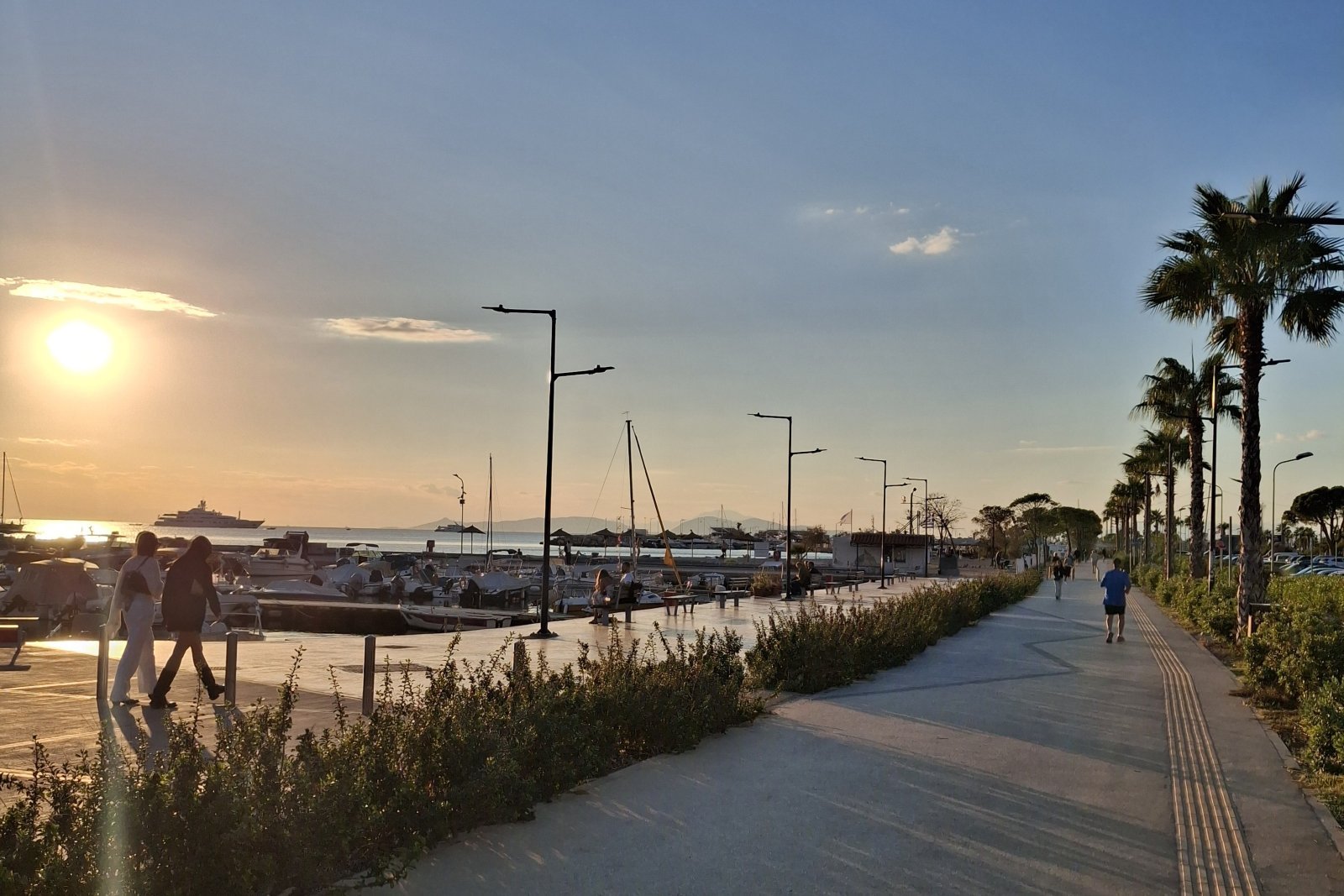 Palm-lined waterfront promenade in Glyfada, Athens Riviera, with marina views at sunset